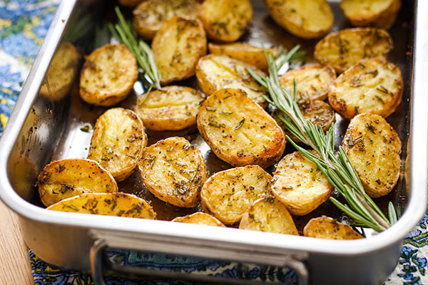 Small roasting pan with potatoes and rosemary.