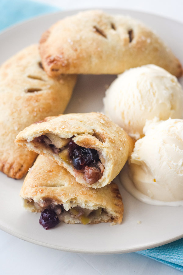 Hand pies on a plate with a scoop of vanilla ice cream.