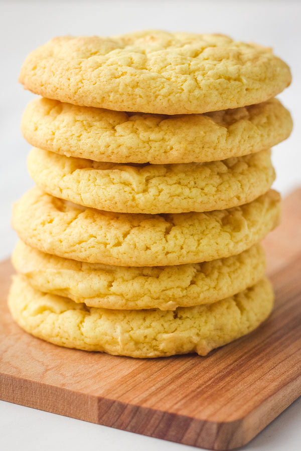 Stack of cookies on a wooden cutting board.