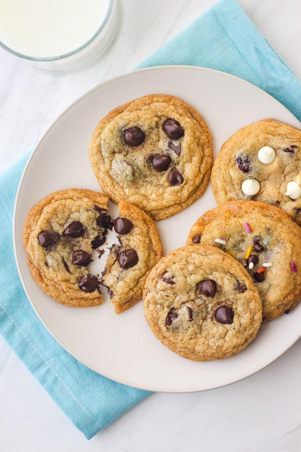 Overhead view of a plate of cookies with a cold glass of milk.