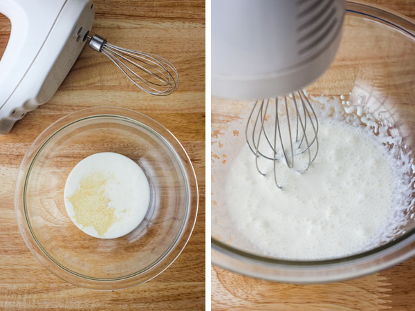 A glass bowl with cream next to a mixer and a bowl of cream whipped with bubbles.