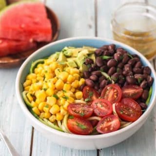 Zucchini noodle salad in a blue bowl.