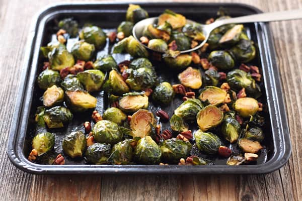 Roasted Brussels Sprouts on a dark baking sheet.