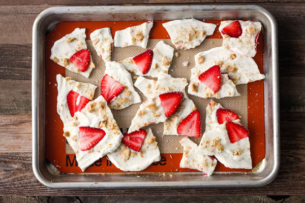 Strawberry Lime Yogurt Bark broken into pieces on a baking sheet.