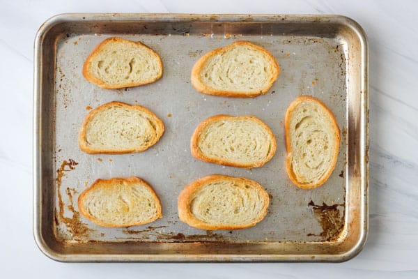 Golden toasted bread slices on a sheet pan.