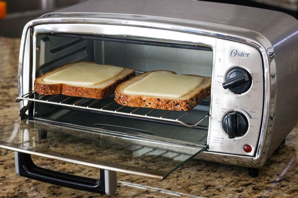 Toasted bread slices with cheese inside a toaster oven.