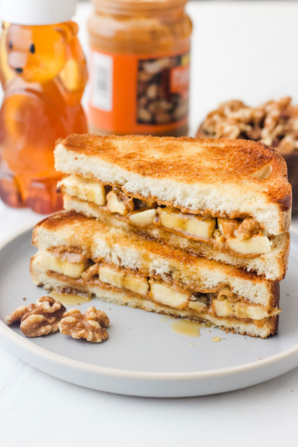 Peanut butter and banana sandwich slices stacked on a blue plate.