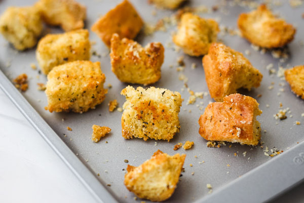 Crispy baked croutons on a metal baking sheet.