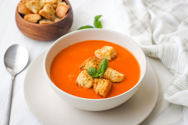 Baked croutons in a bowl of creamy tomato soup.