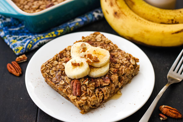 Baked oatmeal square on a white plate with a fork.