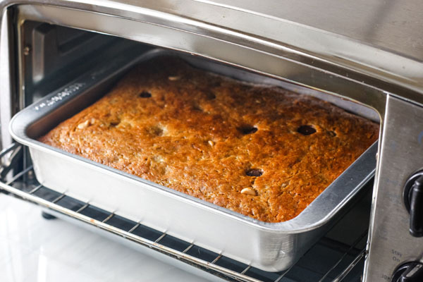 A small cake pan of baked bread inside a toaster oven.