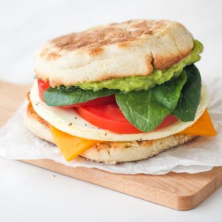 Breakfast sandwich on a small wooden cutting board.