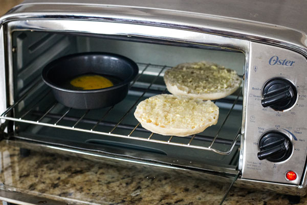 A small pan and split English muffin inside a toaster oven.