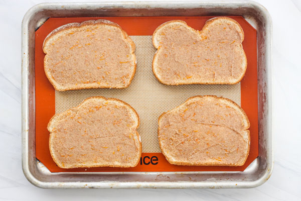 Slices of cinnamon toast on a silpat lined baking sheet.