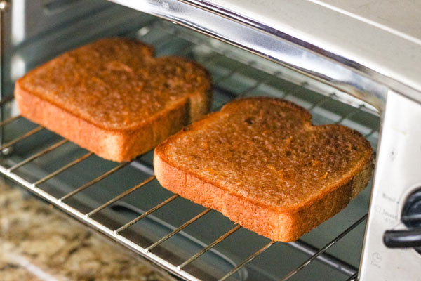 Two slices of browned cinnamon toast inside a toaster oven.