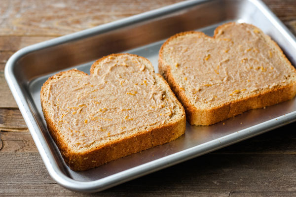 Bread slices spread with cinnamon sugar butter on a small baking pan.