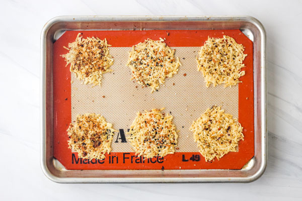 Parmesan baked crisps on a silicone baking mat lined pan.