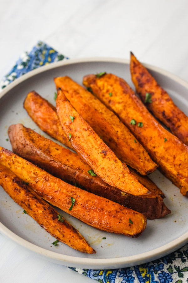 Smoky sweet potato wedges on a blue plate.