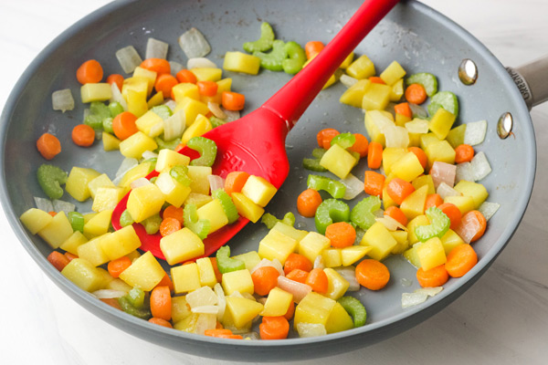 Vegetables cooking in a skillet.