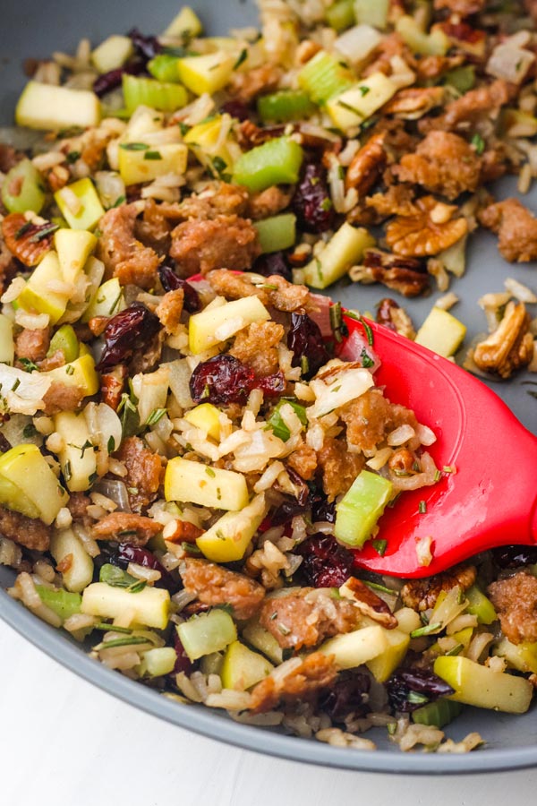 Vegetarian sausage and apple stuffing cooked in a skillet.