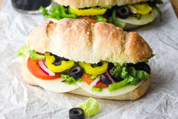 Closeup of sub with provolone cheese slices and crisp fresh veggies.