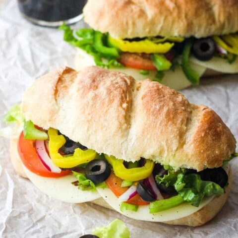 Two veggie subs on a table.