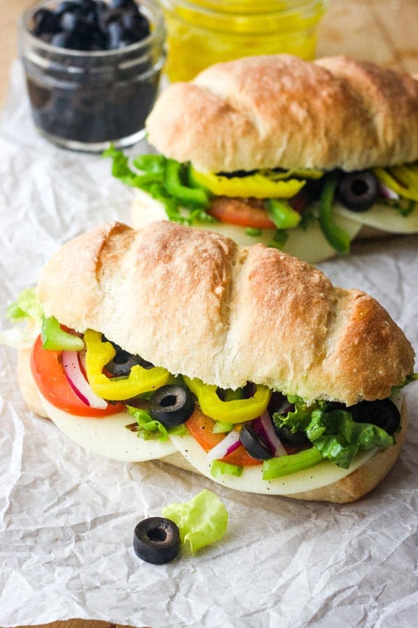 Two veggie subs on a table.