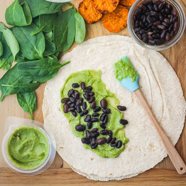 Wrap topped with guacamole and black beans.