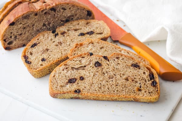 Bread loaf cut into slices on cutting board.