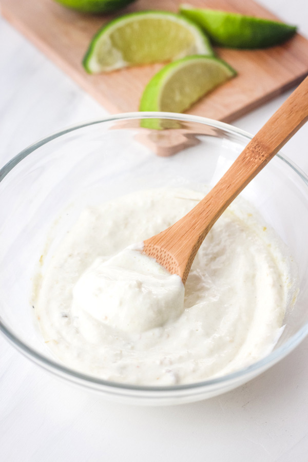 wooden spoon stirring dip in a small glass bowl.