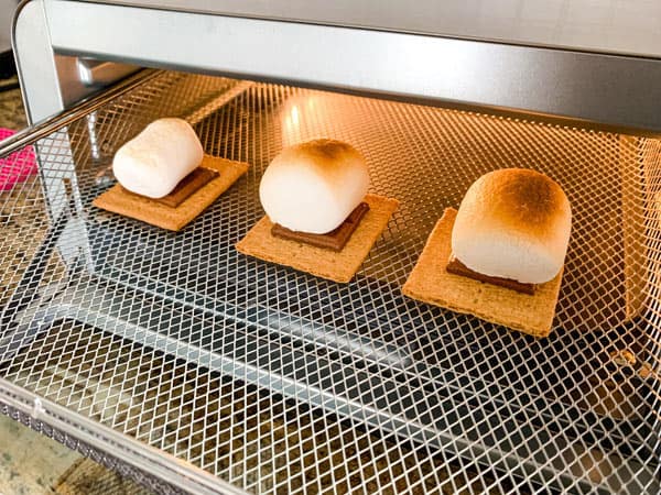 Puffy and toasted s'mores in an air fryer oven basket.