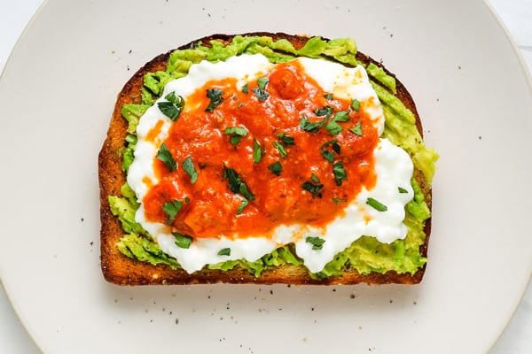 Mashed avocado with cottage cheese and salsa on toast.