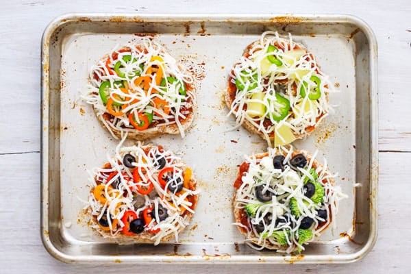 Overhead view of bagels with toppings and cheese.