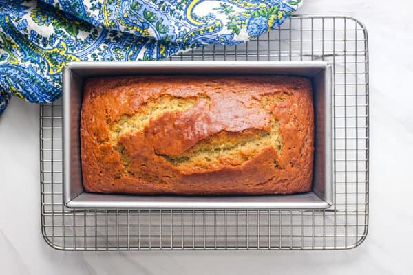 Loaf of toaster oven banana bread cooling on a wire rack.