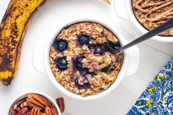 Closeup of spoon scooping blueberry baked oatmeal from a ramekin.