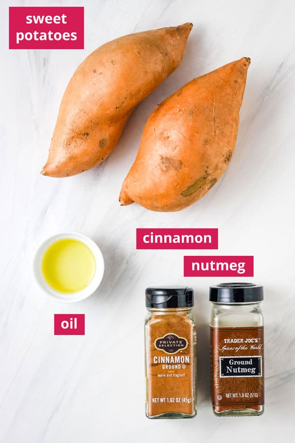 Sweet potatoes, ramekin of oil, and jars of cinnamon and nutmeg labeled on a table.
