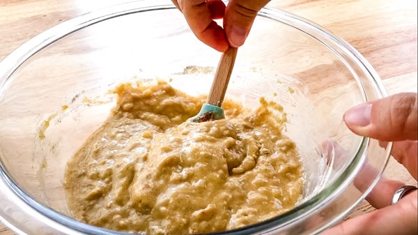 Lumpy batter stirred in a glass bowl.