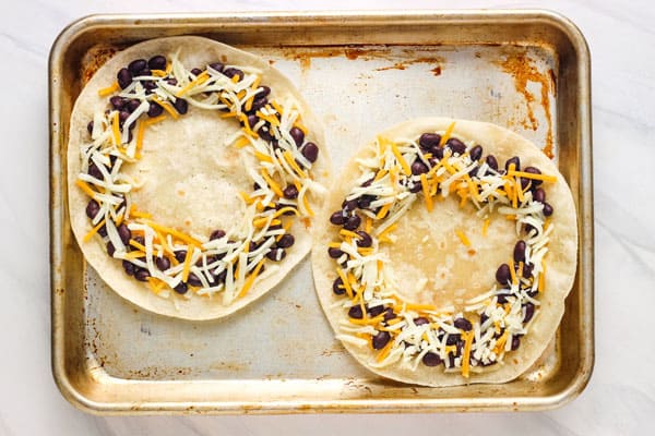 Tortillas on a pan with bean and cheese wreaths.
