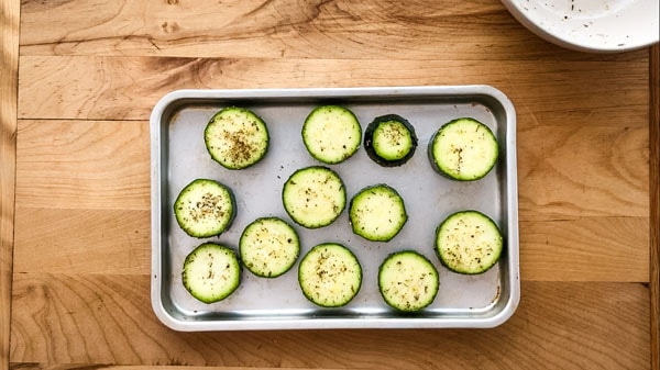 Zucchini slices on a small sheet pan.