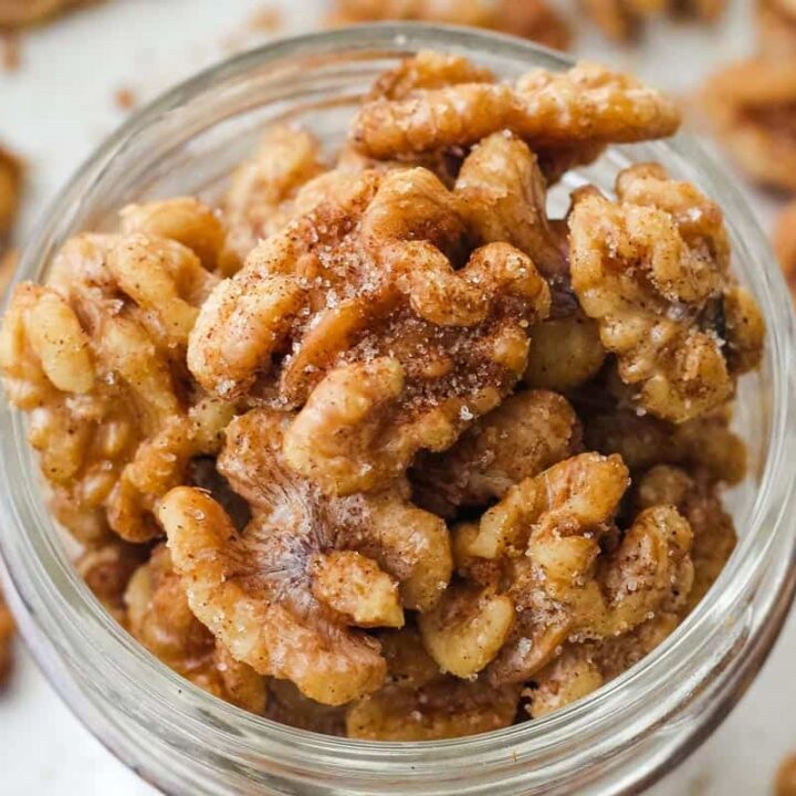 Close up of cinnamon sugar walnuts in a mason jar.