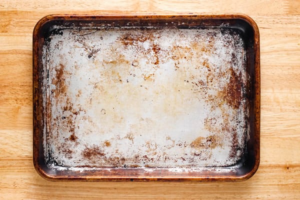 Overhead view of stained sheet pan cleaned in the center.