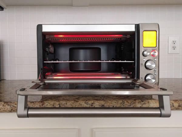 Countertop oven with door open showing red hot heating elements.