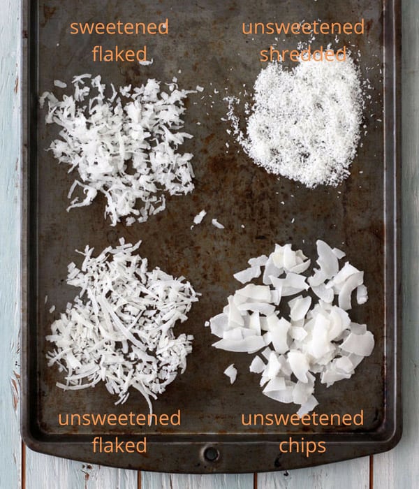Shredded, flake, and sweetened coconut on a baking sheet.