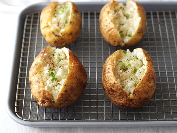 Baked potatoes on a cooling rack.