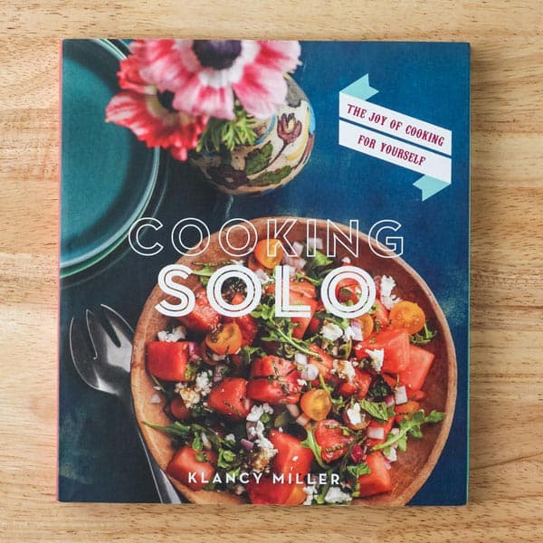 Cooking Solo cookbook cover with a bowl of watermelon salad and flowers.