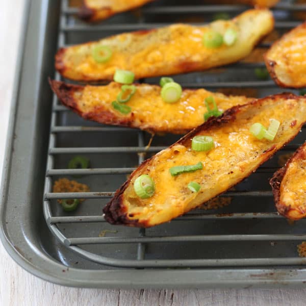 Crispy potato skins with melted cheese and sliced green onions.