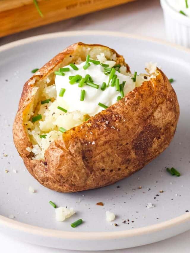 Baked potato topped with Greek yogurt and fresh chives.