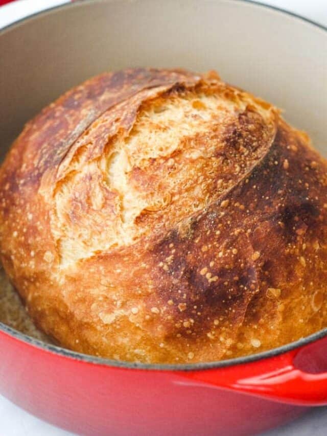 Closeup of bread loaf in red dutch oven.