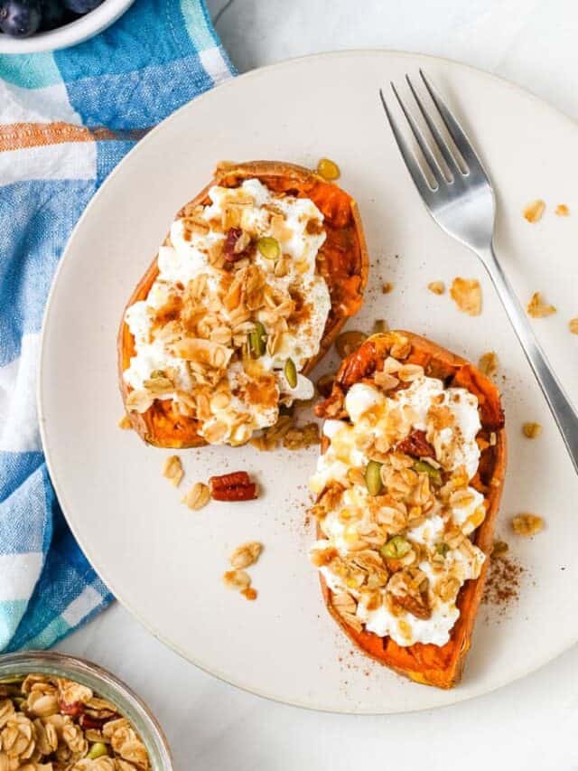 Overhead view of sweet potato halves on a plate topped with cottage cheese and granola.