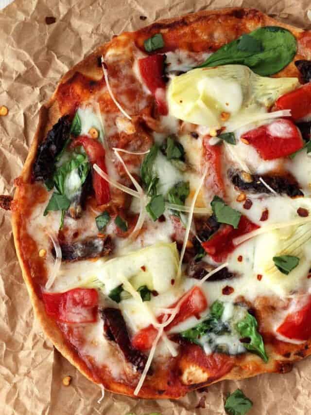 Closeup of melted cheese and vegetables on a baked tortilla.